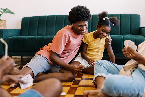 Family fun at home: Kids playing a card game with their parents