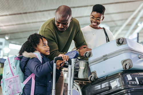 African kid talking with her parents at airport