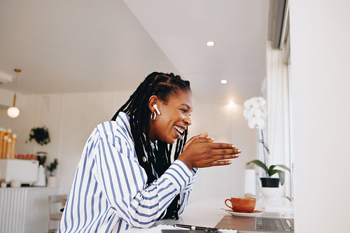Smiling black businesswoman having a virtual meeting with a client in a cafe