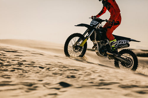 Motocross biker riding bike in the desert