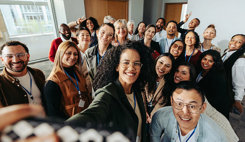 Diverse group of colleagues enjoying a fun selfie to capture teamwork spirit at the office
