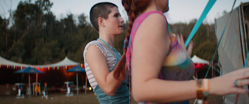 Three happy young women dancing together at a festival