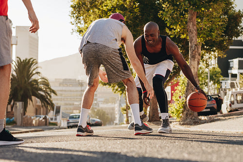 Men playing basketball on street
