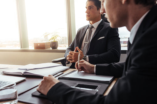 Businessman sitting at his desk with colleague