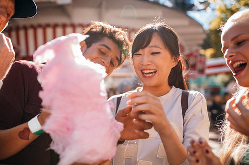 Young people sharing cotton candy outdoors