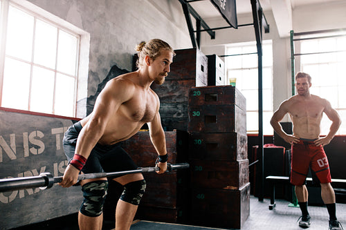 Bodybuilder lifting barbell at the gym