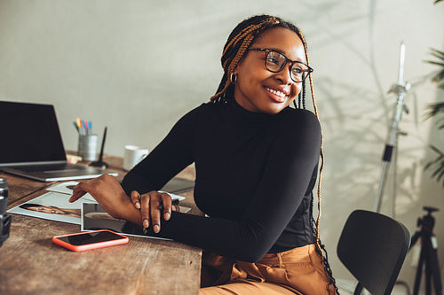 Imaginative young woman smiling in her home office