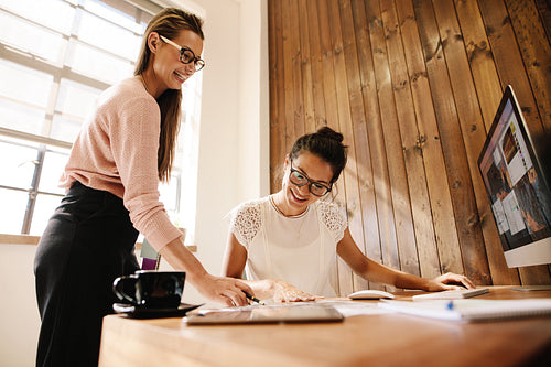 Smiling creative business women at the office desk