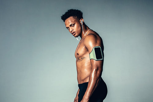 Muscular young man listening to music