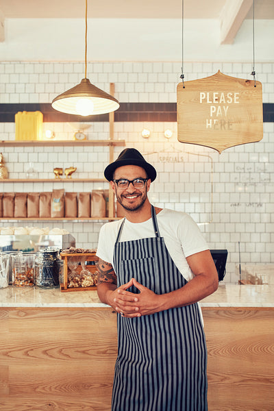 Coffee shop worker smiling to camera