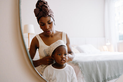 Mother dressing her young child
