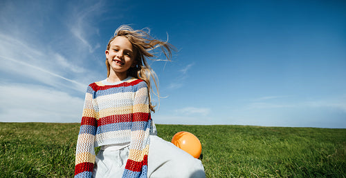 Girl enjoying carefree summer moment in open grassy field