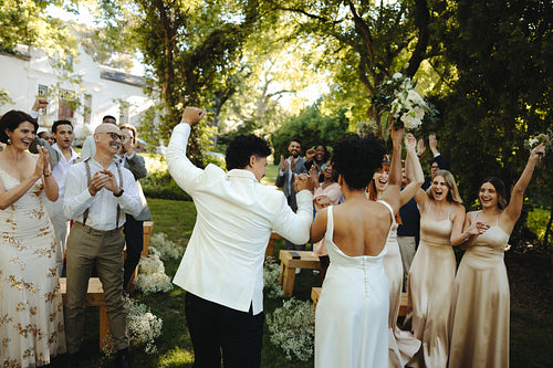 Joyful wedding celebration outdoors showcasing lively emotions and supportive loved ones