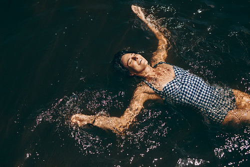 Happy woman on a holiday swimming in a lake