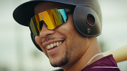 Baseball player smiles, ready for action