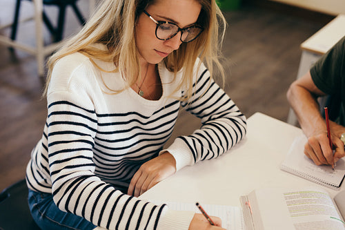 Female students studying with classmates