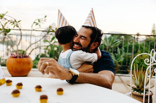 Father and child hugging during a festive outdoor celebration