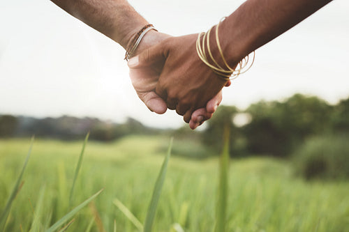 Young couple holding hands in the field