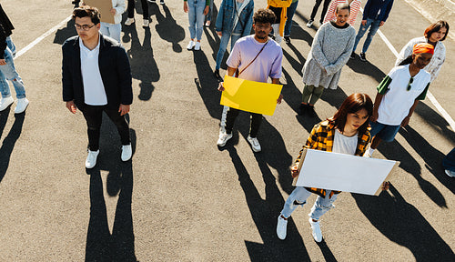 Group of diverse ypung people holding blank signs during an outdoor protest