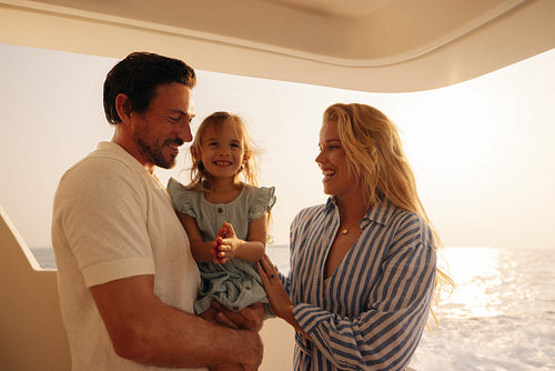 Happy family having a joyful vacation on a yacht at sunset