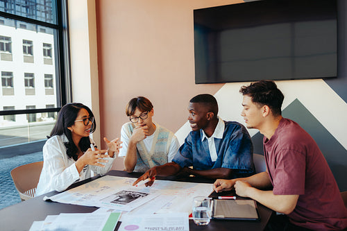Diverse group engaged in intense discussion during a study group meeting with notes and tablet on the table
