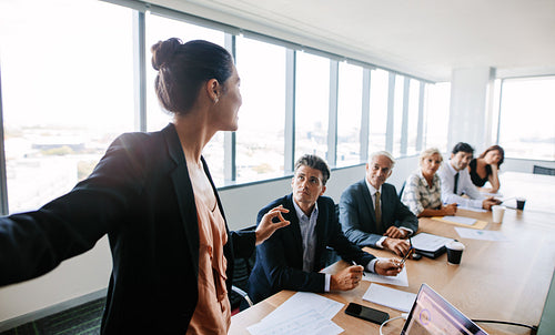 Asian businesswoman giving presentation to coworkers