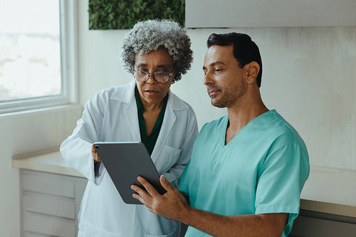 Doctor joins dental team using tablet for consultation in clinic