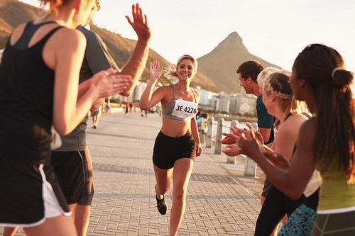 Group of spectators cheering on runners before the finish line