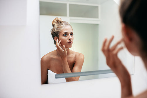 Female in bathroom looking into the mirror
