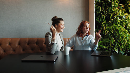 Creative business women having a discussion and using a laptop
