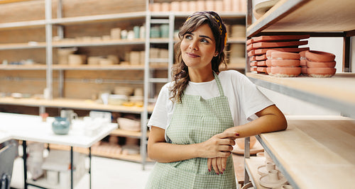 Female potter thinking of new creative ideas for her ceramic shop
