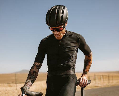 Cyclist taking break on the road
