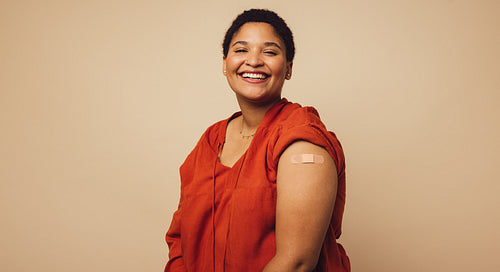 Woman showing her arm after receiving a vaccine