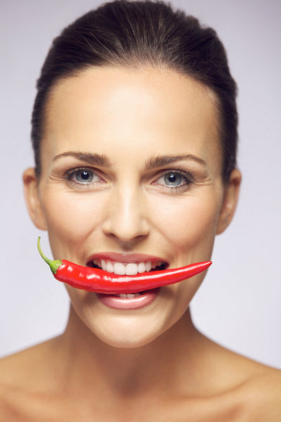 Beauty with hot pepper in her mouth 
