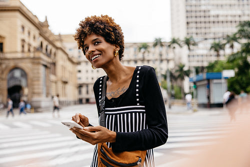 Happy women standing in the street waiting for her taxi cab