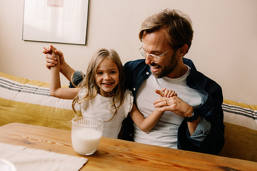 Father and daughter share joyful moment at table