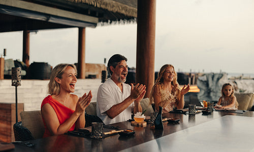 Multi-generational family enjoying fine dining at a tropical resort setting