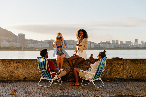 Young friends relaxing by the waterfront during sunset