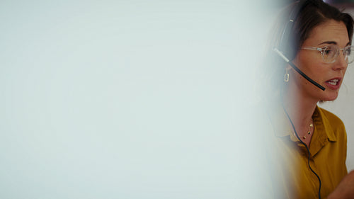 Businesswoman in headset and glasses talks and gestures during a video call