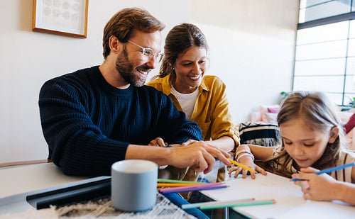 Mom, Dad and daughter are enjoying a crafts session at home