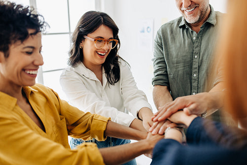 Diverse business team stacking hands together in a huddle