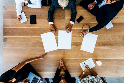 Group of businesspeople placing blank placards on table