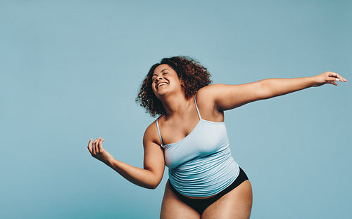 Athletic plus size woman dancing in a studio, expressing body positivity