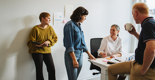 Colleagues discussing and working together in office