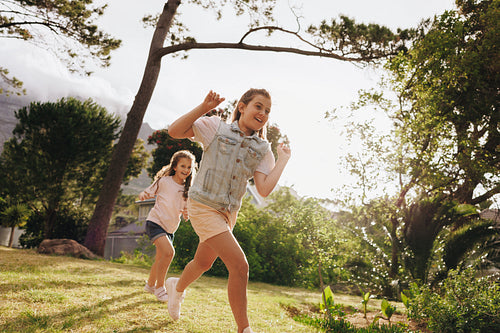 Two children playing energetically in a sunny outdoor park setting