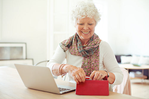 Cheerful Old Woman Getting Something from Her Wallet
