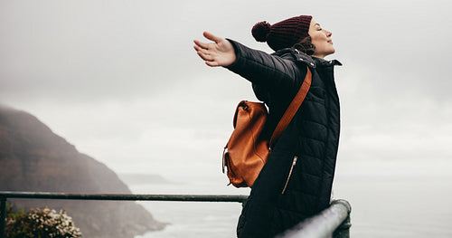 Woman happily breathing in the fresh sea air