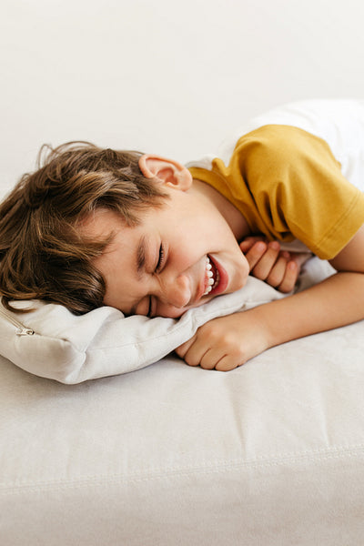 Laughing boy lying on sofa