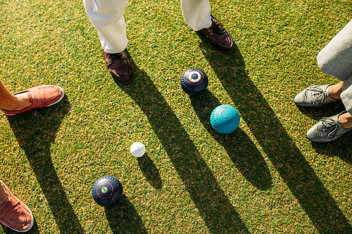 Top view of boules on ground with people standing around
