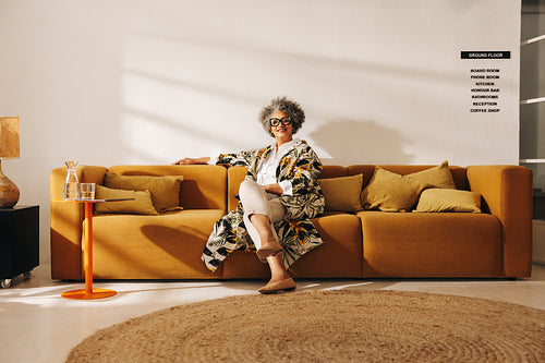 Successful businesswoman sitting on a couch in an office lobby